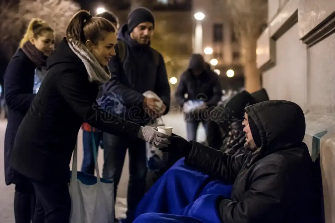 Bénévoles en maraude solidaire partageant une boisson chaude avec une personne sans-abri